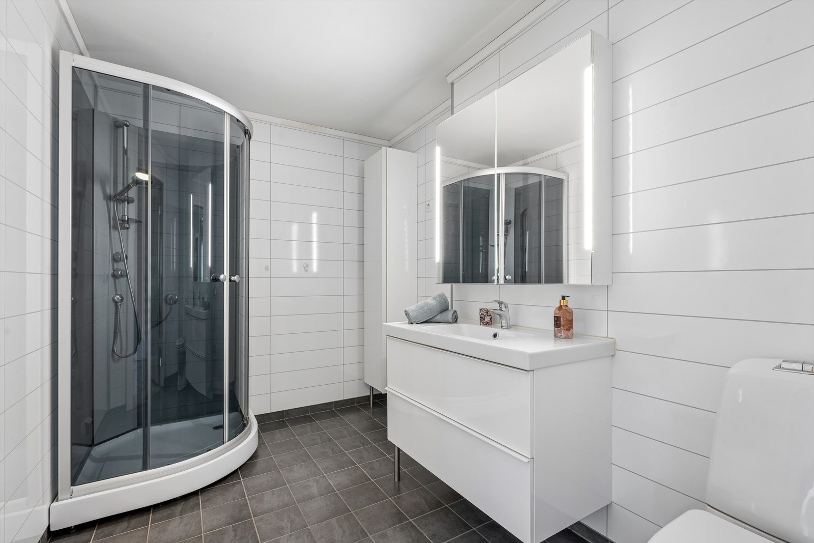 Badet har flislagt gulv med elektriske varmekabler og baderomsplater på veggene. Galleribilde