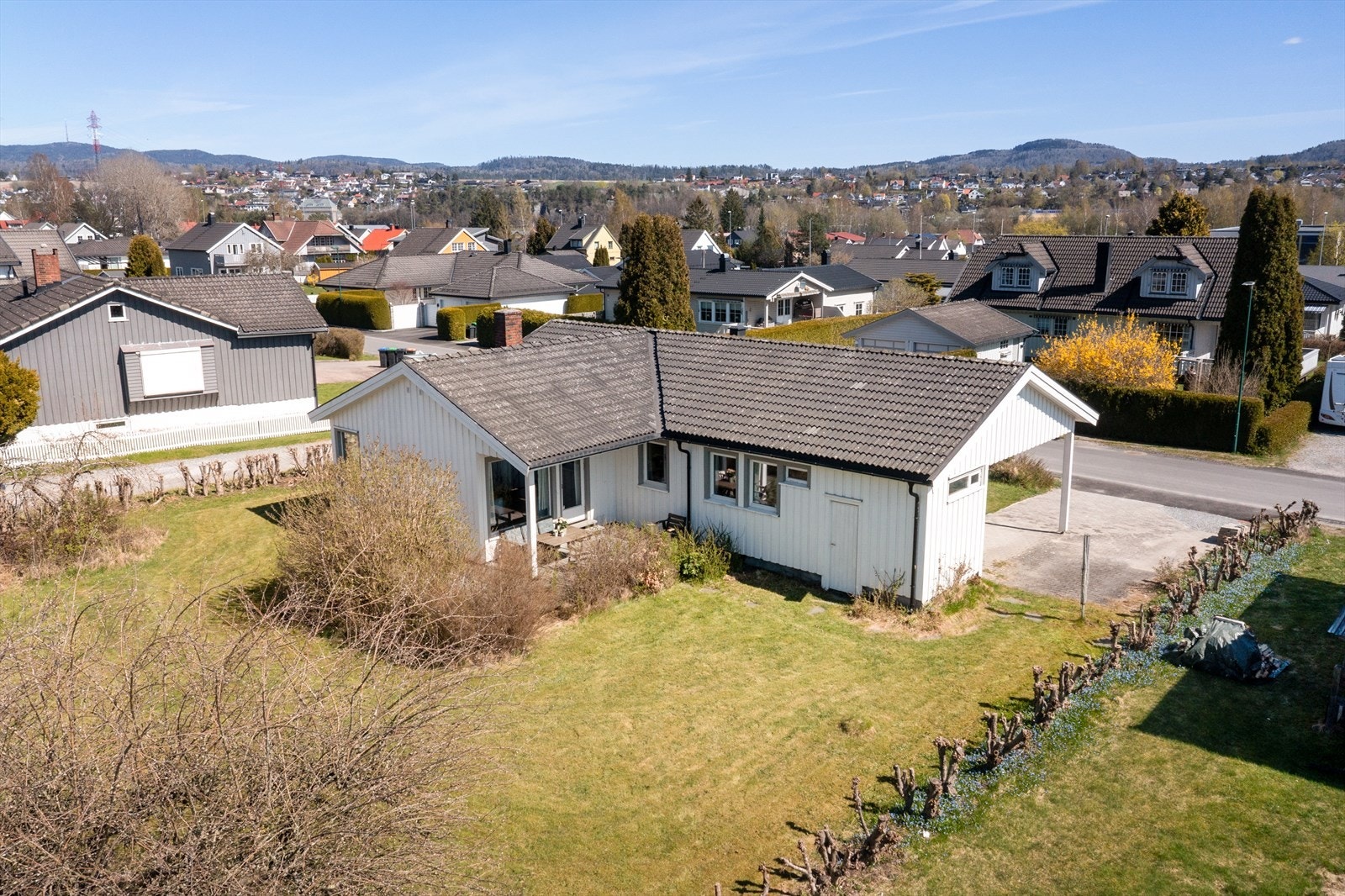 Eiendommen sett fra luften, med hagen og carporten. For den aktive familien ligger Tollnes stadion med fotballbaner i gangavstand fra boligen. Galleribilde