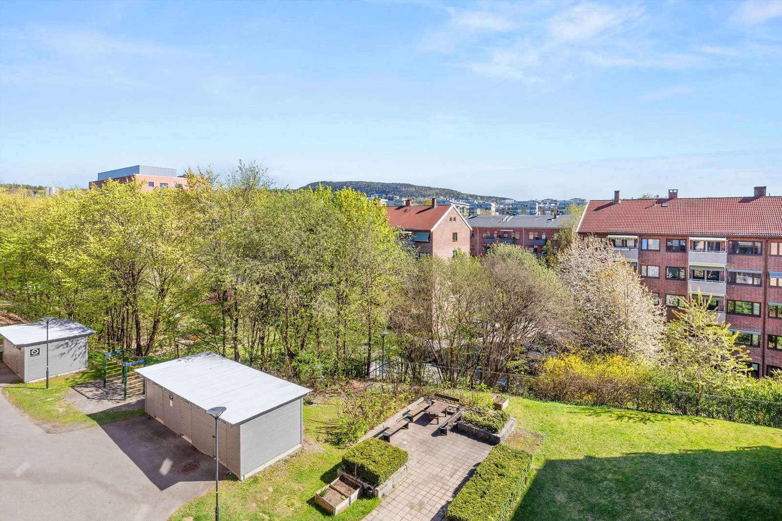 Fra balkongen har man utsyn mot sameiets pent opperbeide fellesområder/bakgård. Galleribilde