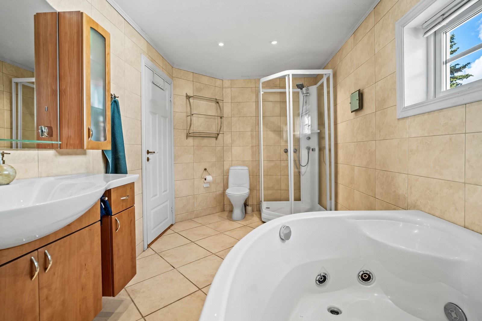 Badet har fliser på gulv med varmekabler og dusjhjørne. Galleribilde