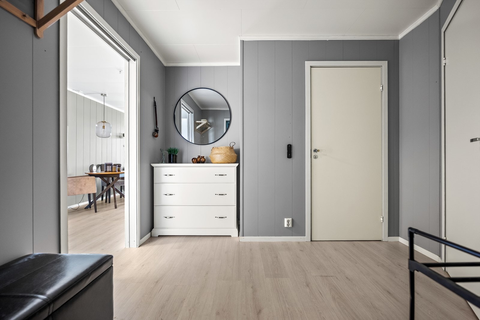 Entréen har 1-stavs laminatgulv og malte veggplater i en pen gråtone. Galleribilde