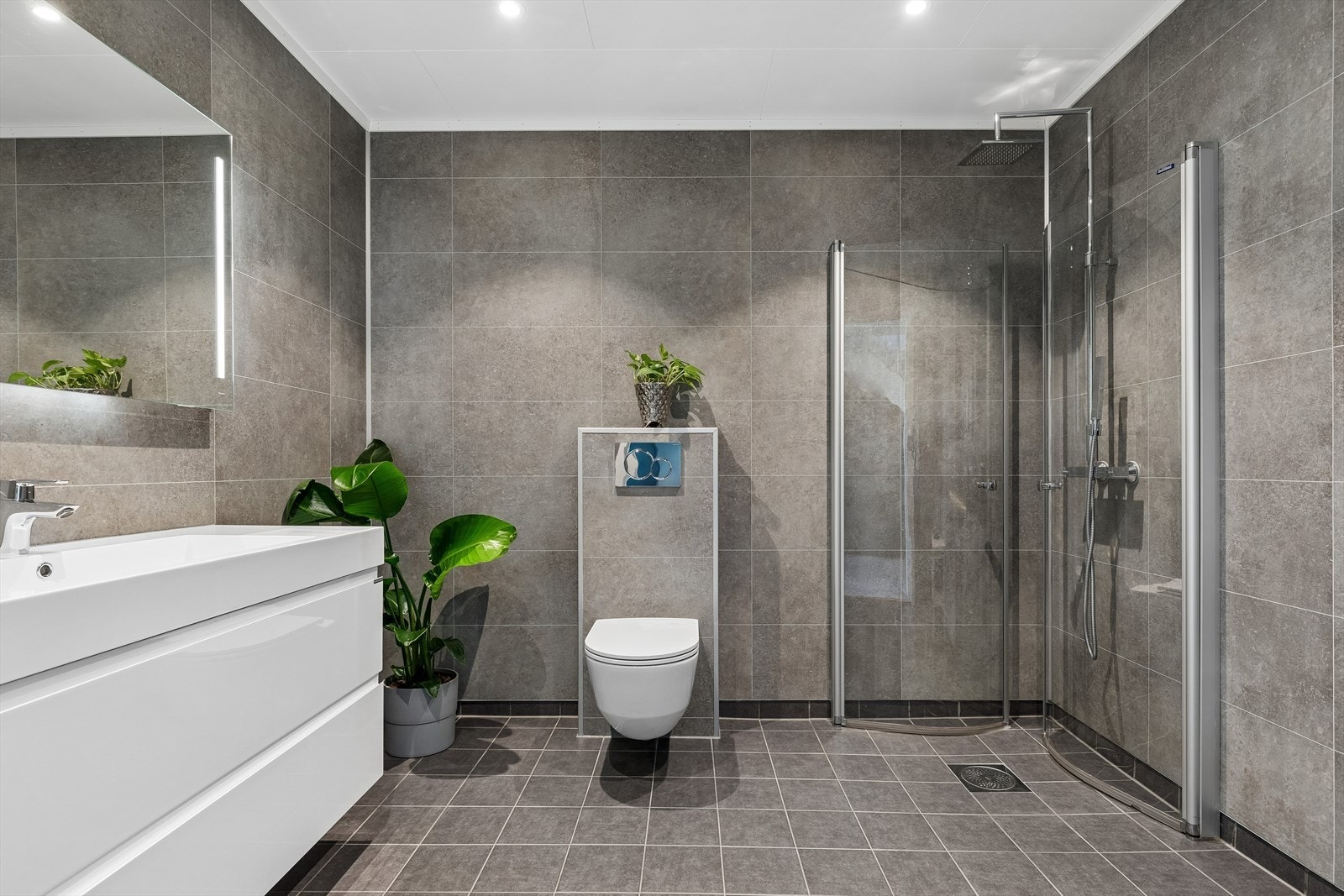Her er badet i underetasjen. Her er det klargjort for badekar. Badet har vegghengt toalett og servant med integrert belysning i speilet. Galleribilde