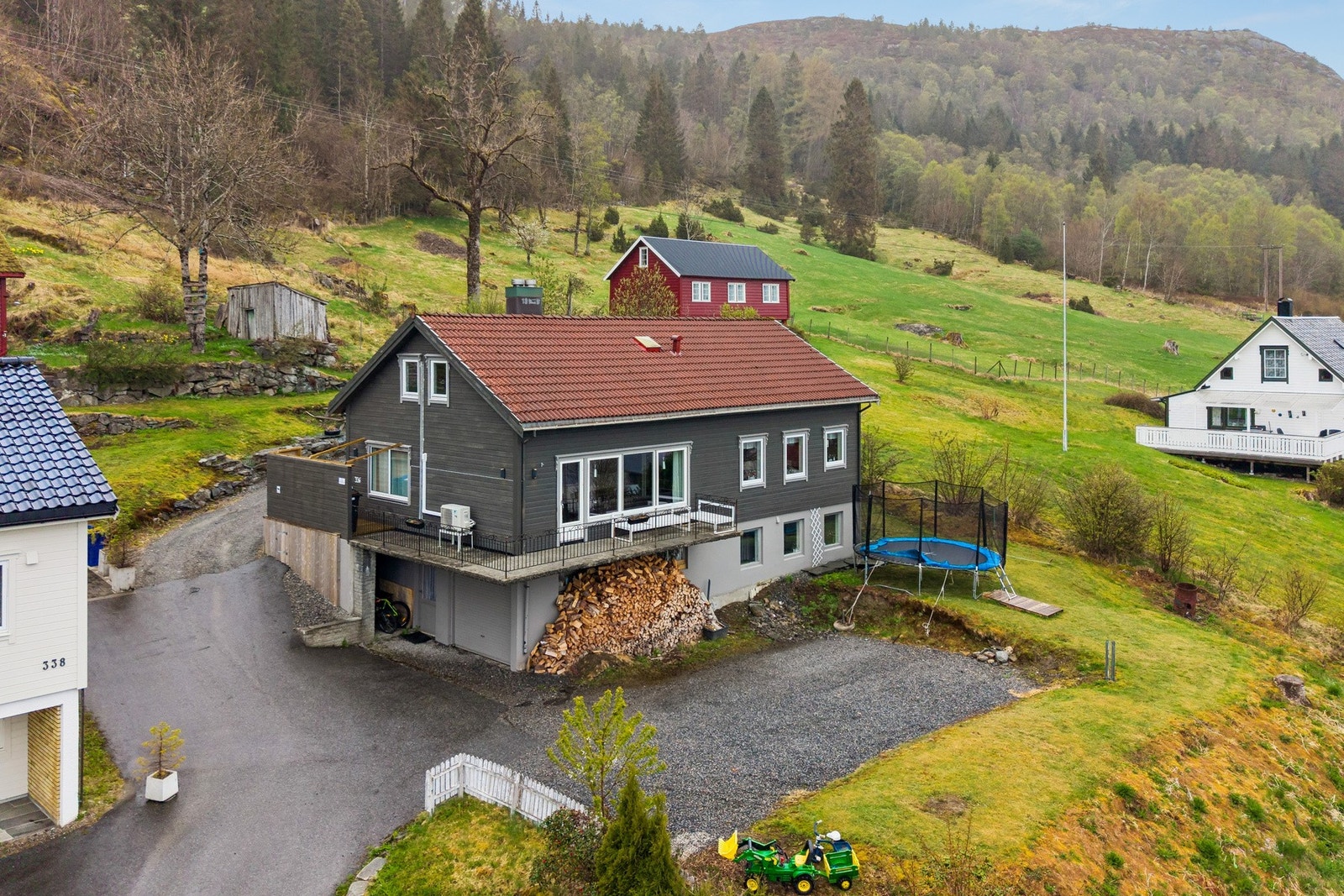 Tomten er opparbeidet med forstøtningsmurer av murstein, plen og beplantning. Galleribilde