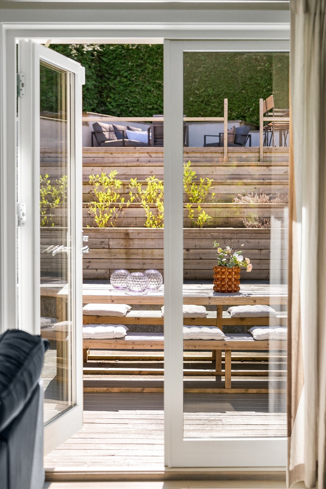 Fra stuen er det direkte adkomst til de store terrassearealene som omkranser boligen og gir en naturlig forlengelse av oppholdsrommet. Galleribilde