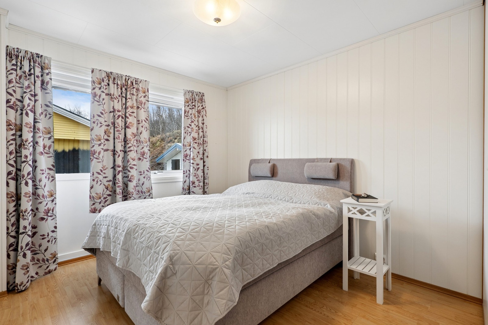 Boligen har totalt fire soverom. Her er ett av de to i andre etasje, med vegger kledd i malt panel. Galleribilde