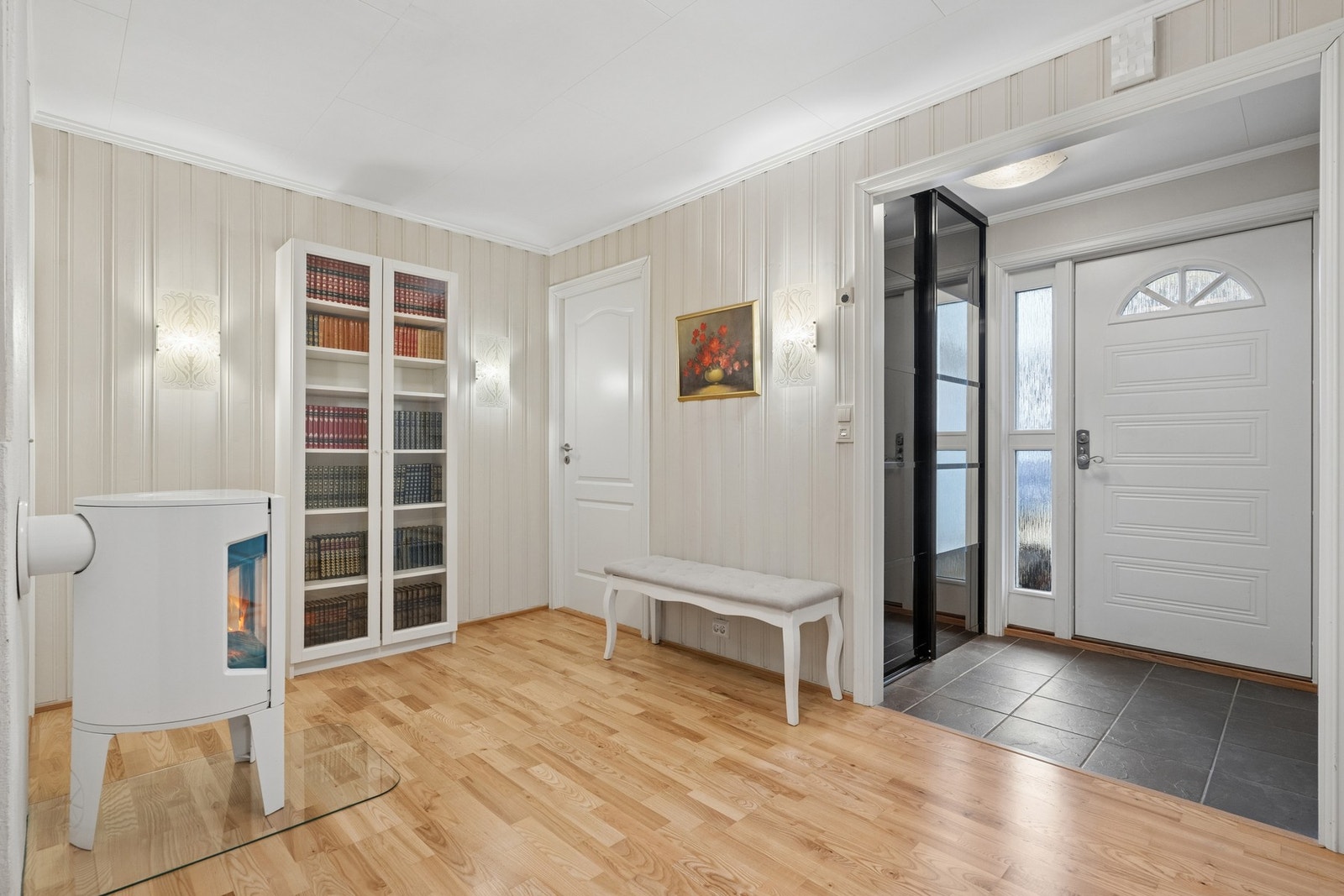 Velkommen inn i underetasjen. Entréen har flislagt gulv og leder inn til en romslig hall. Galleribilde