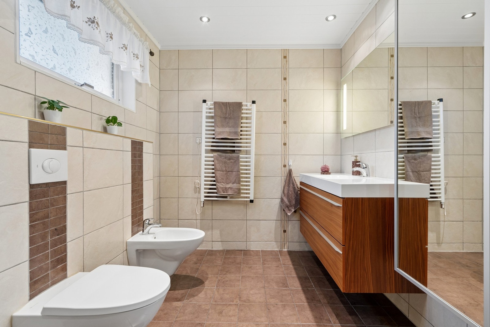 Badet er utstyrt med en moderne innredning med nedfelt servant, vegghengt toalett og bidé. Galleribilde
