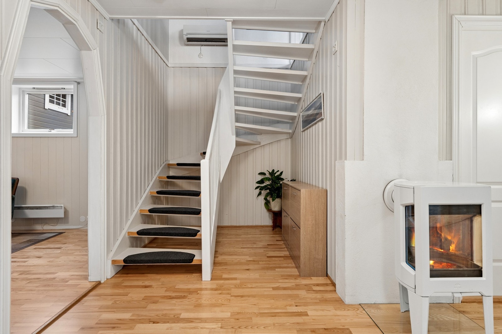 Den malte tretrappen forbinder boligens to plan. Oppvarming skjer blant annet via en luft-til-luft varmepumpe. Galleribilde