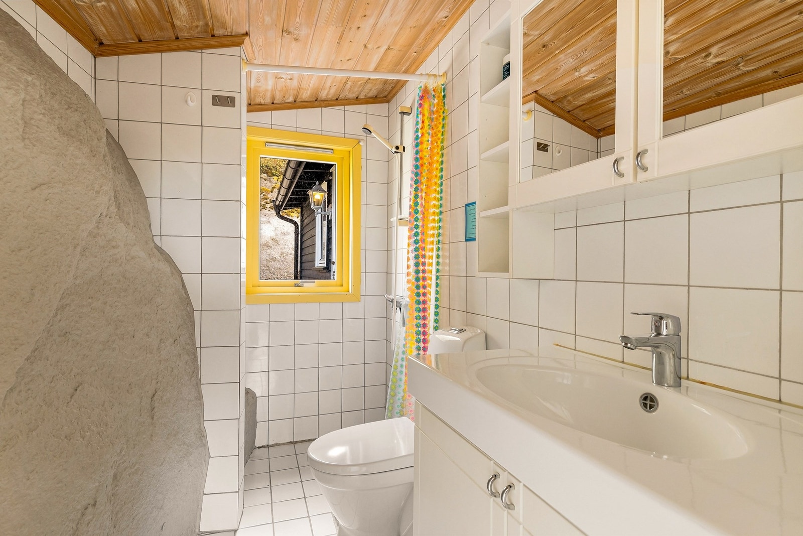 Badet har varmekabler i gulvet. En spesiell detalj er fjellet som er integrert i den ene veggen. Galleribilde