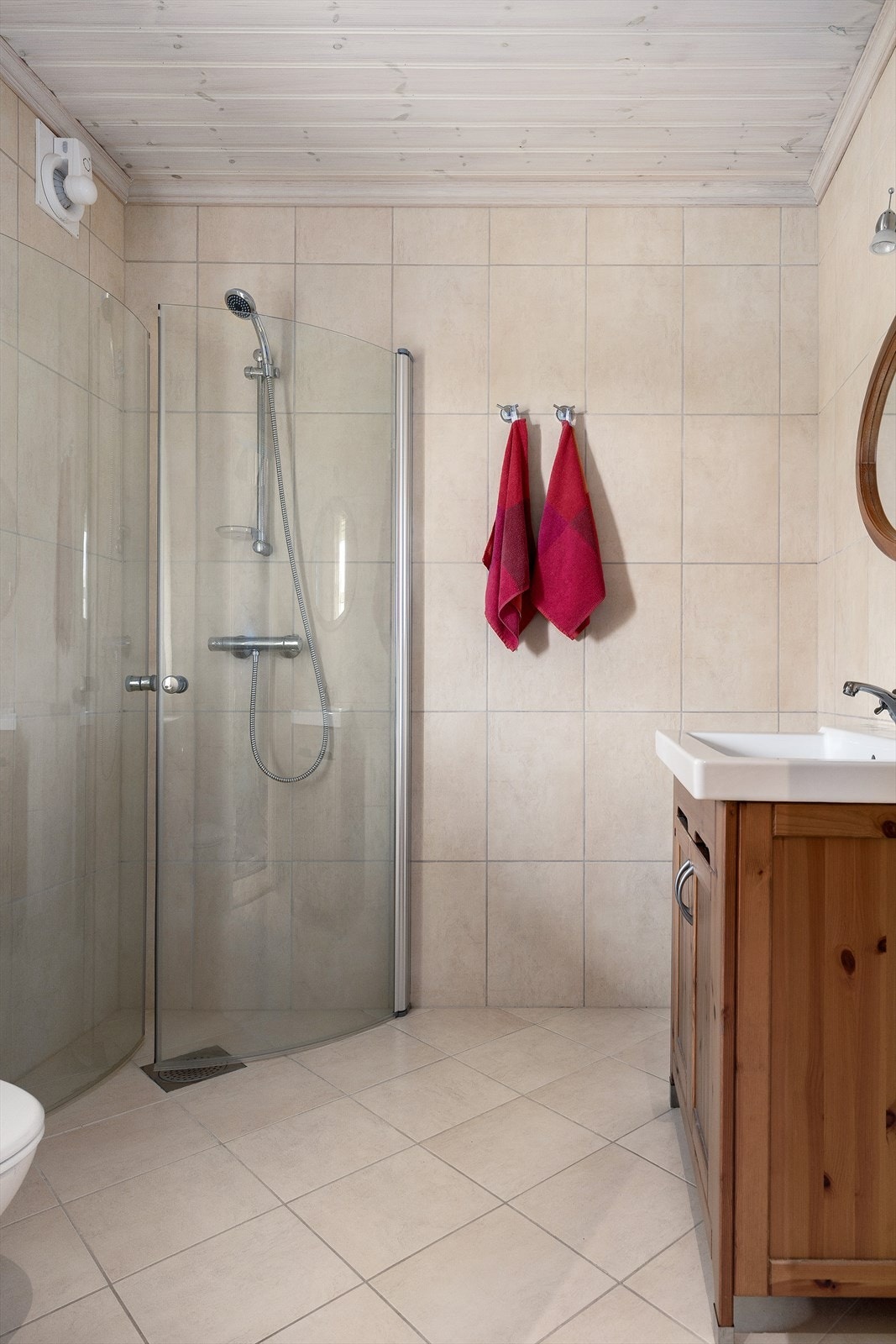 Badet i første etasje er helfliset og utstyrt med dusjhjørne, vegghengt toalett og servantinnredning. Galleribilde