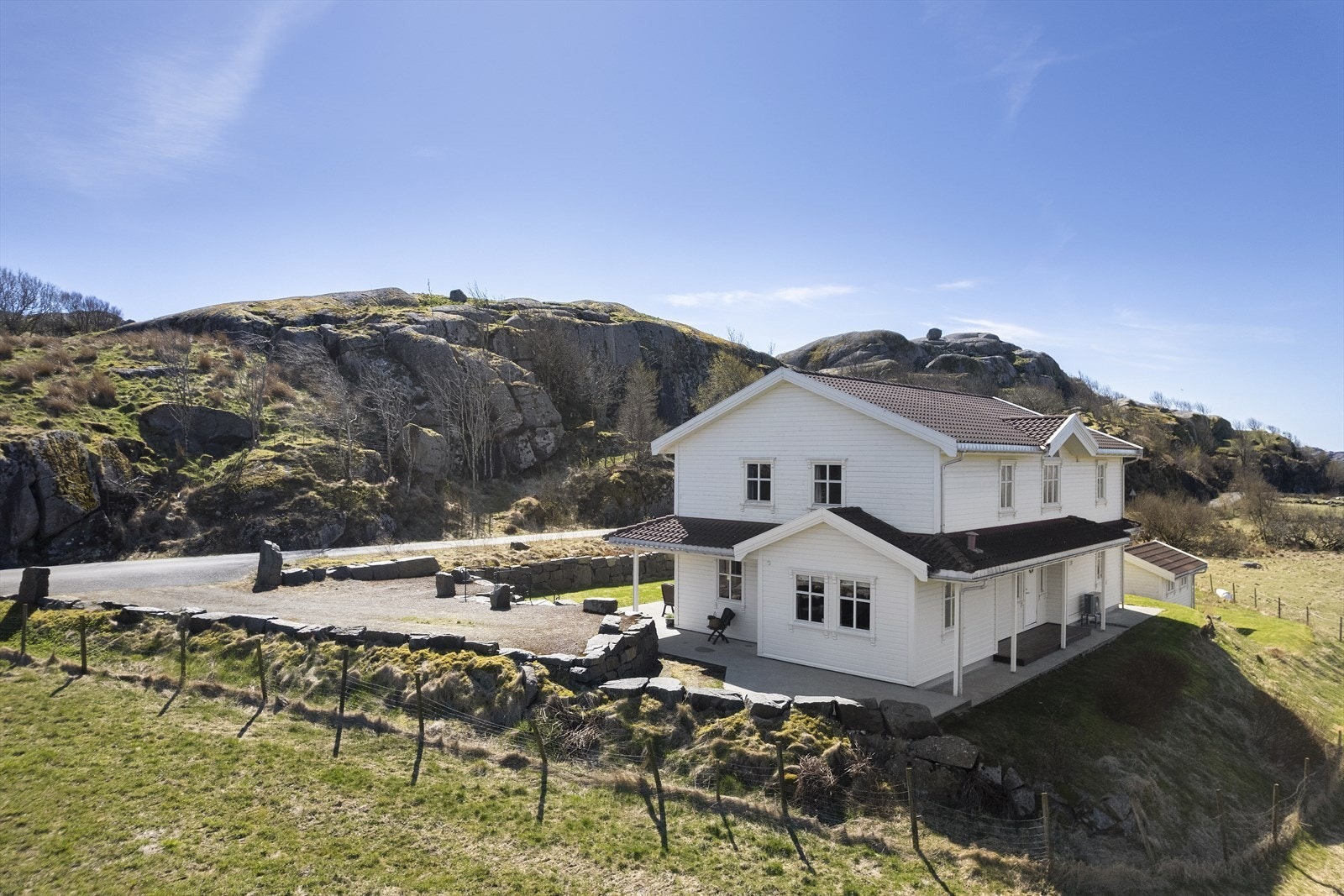 Tomten er rammet inn av en forstøtningsmur av lødd naturstein. Galleribilde