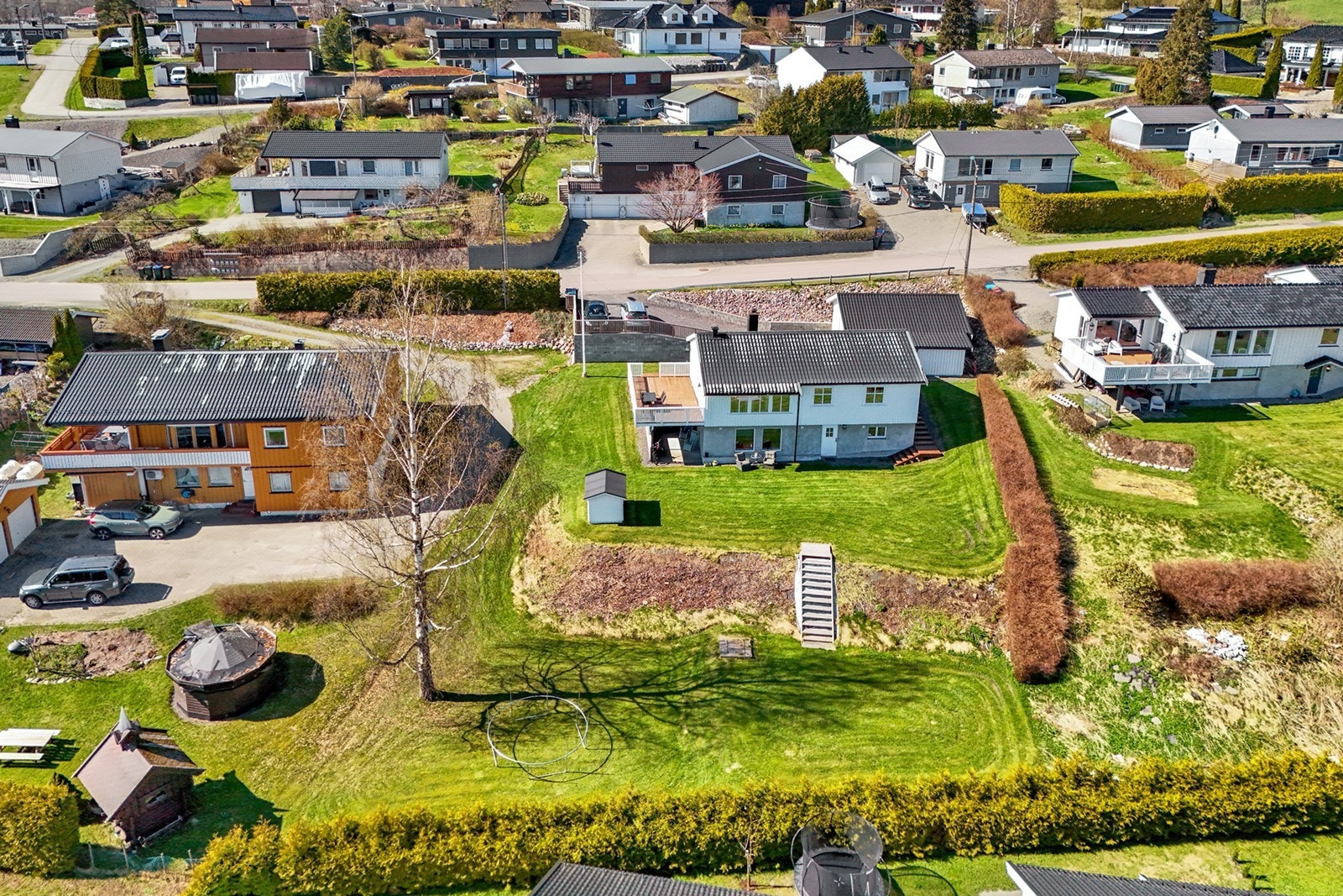 Eiendommen har en stor og pent opparbeidet tomt med plen og beplantning. Galleribilde