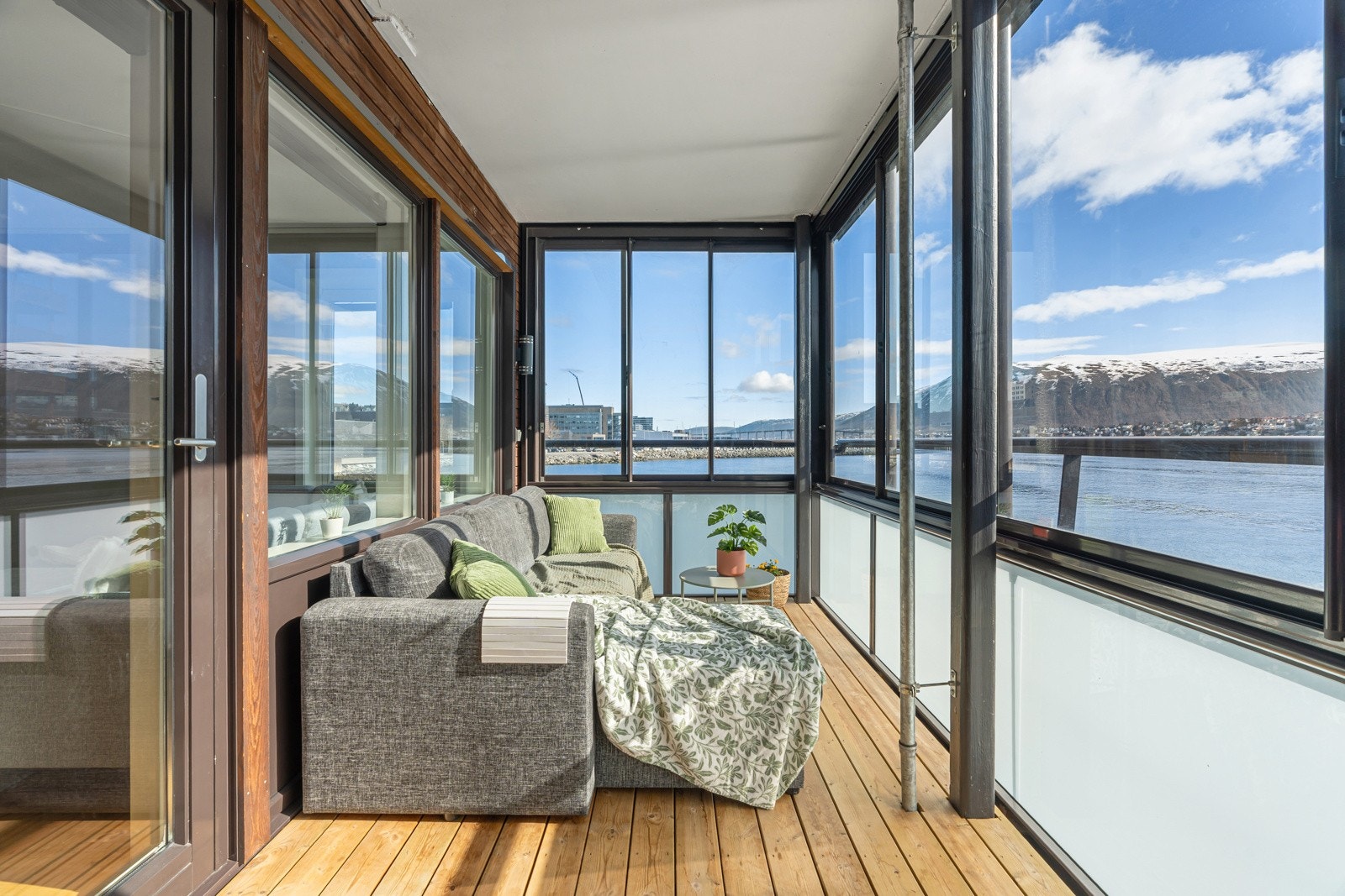 Innglasset balkong med en spektakulær utsikt mot havet og de vakre fjellene.