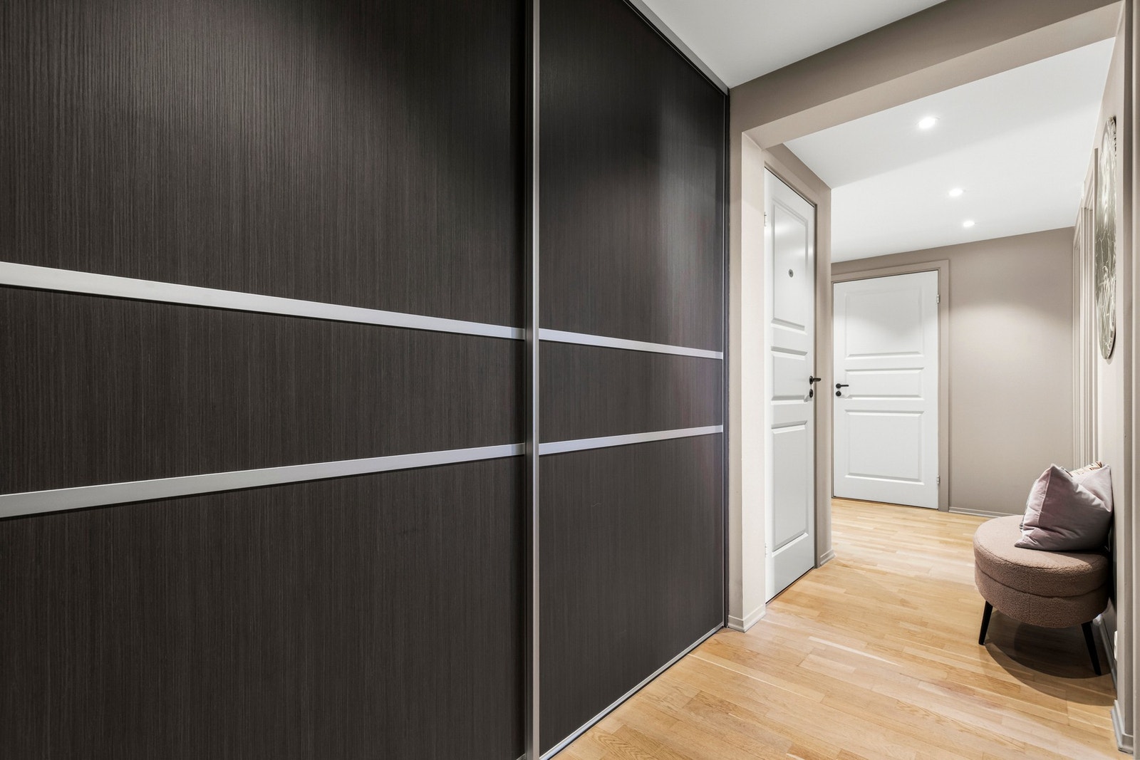 Romslig inngangsparti med malte veggflater og downlights i himlingen som gir et godt lys. Galleribilde