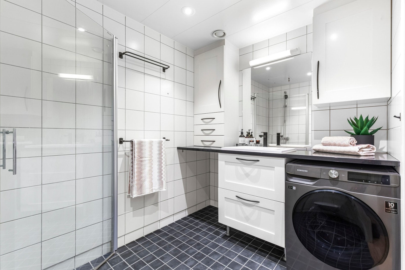 Badet er flislagt med termostatstyrte varmekabler i gulv. Himlingen er nedsenket og det er innfelte downlights som gir godt lys. Galleribilde