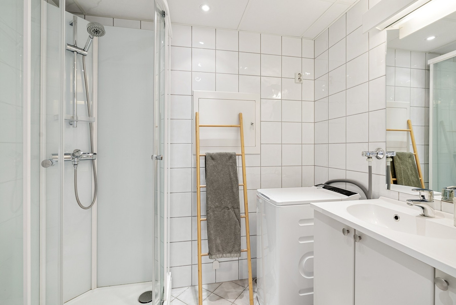 Flislagt bad med varme i gulv og downlights i himling. Dusjkabinett, toalett og opplegg for vaskemaskin. Galleribilde