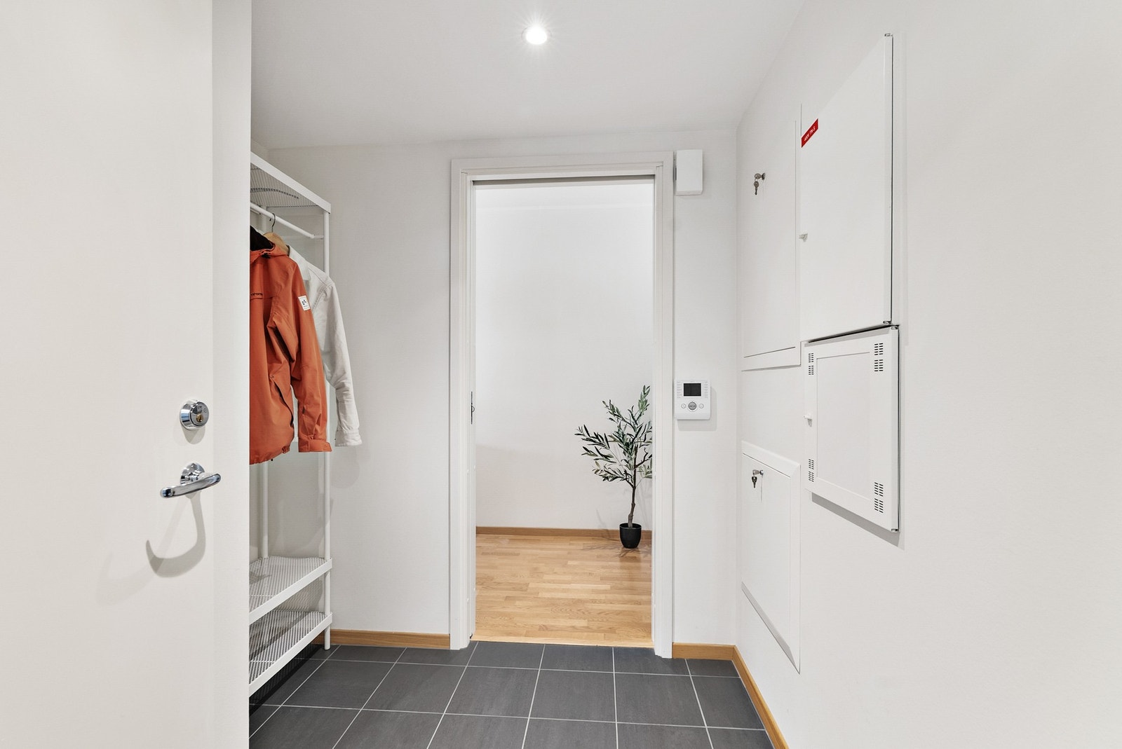 Lys og innbydende entré med downlights i himling. Flislagt gulv med varmekabler. Calling-anlegg. Galleribilde