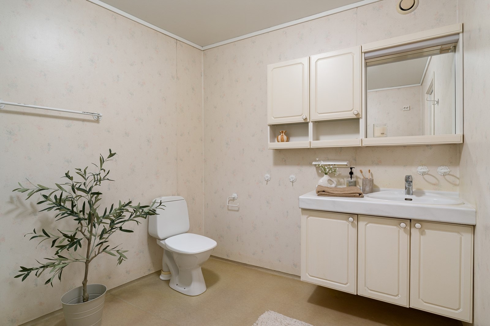 Badet er fra byggeåret, med vinylbelegg på gulv og sveist belegg på veggene. Rommet har mekanisk avtrekk i taket. Galleribilde
