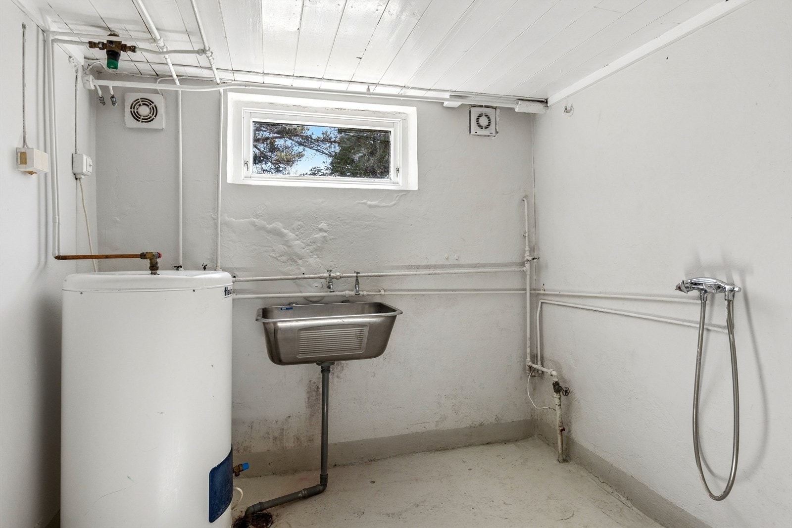 Praktisk vaskerom i underetasjen med opplegg for vaskemaskin, utslagsvask samt en varmtvannsbereder fra 2005. Galleribilde