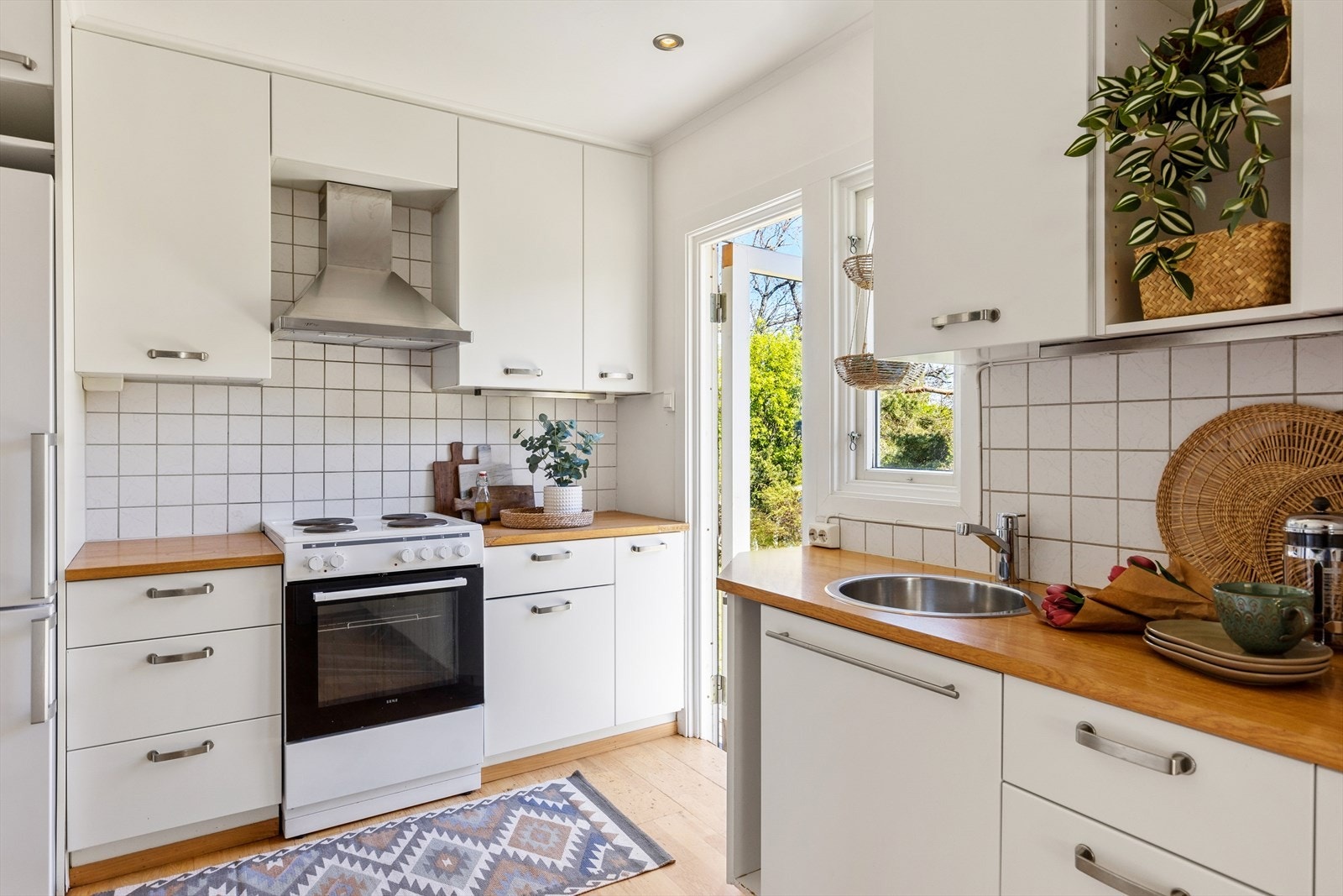 Kjøkkeninnredning med glatte fronter og ventilator med avtrekk ut av rommet. Galleribilde