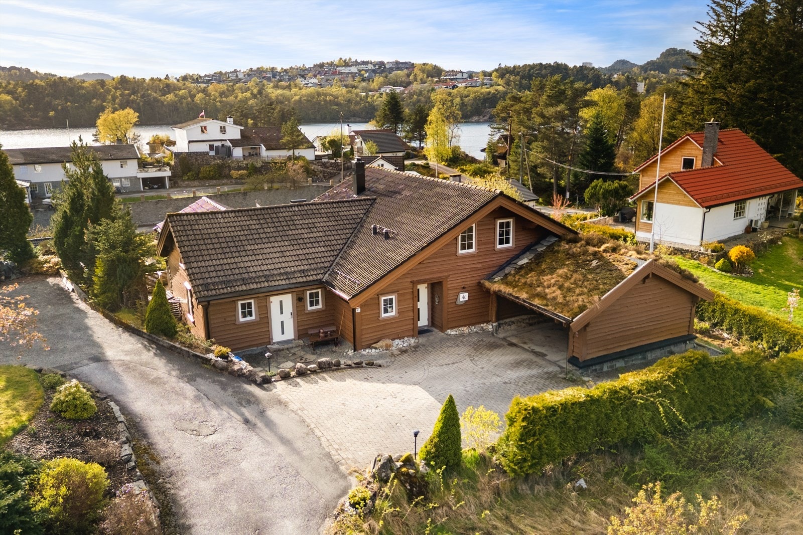Boligen har gode parkeringsforhold med egen biloppstillingsplass og tilhørende carport med torvtak, hvor det i 2020 ble installert elbillader. Galleribilde