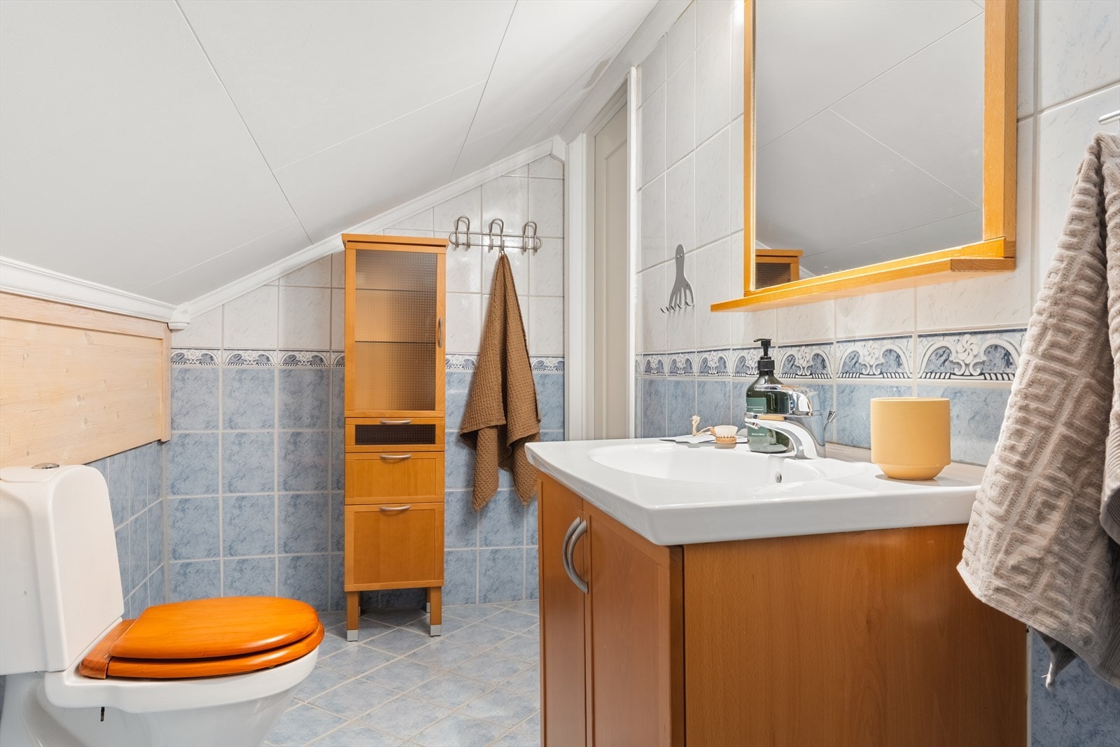 Badet er innredet med toalett, dusj og servant møblement med speil. Mekanisk avtrekkventil. Galleribilde