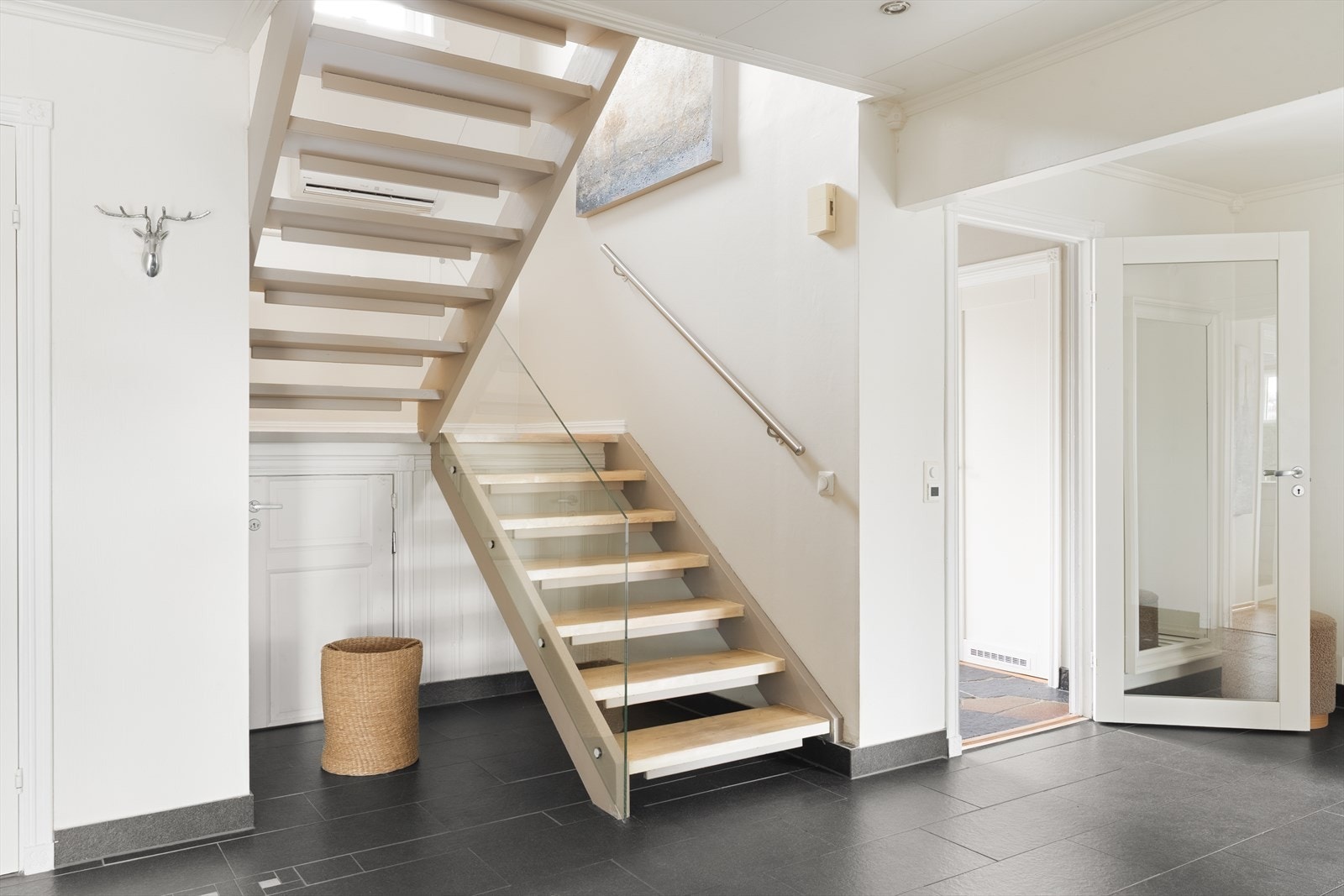 Den elegante tretrappen med rekkverk av glass fører deg opp til boligens 2. etasje. Galleribilde