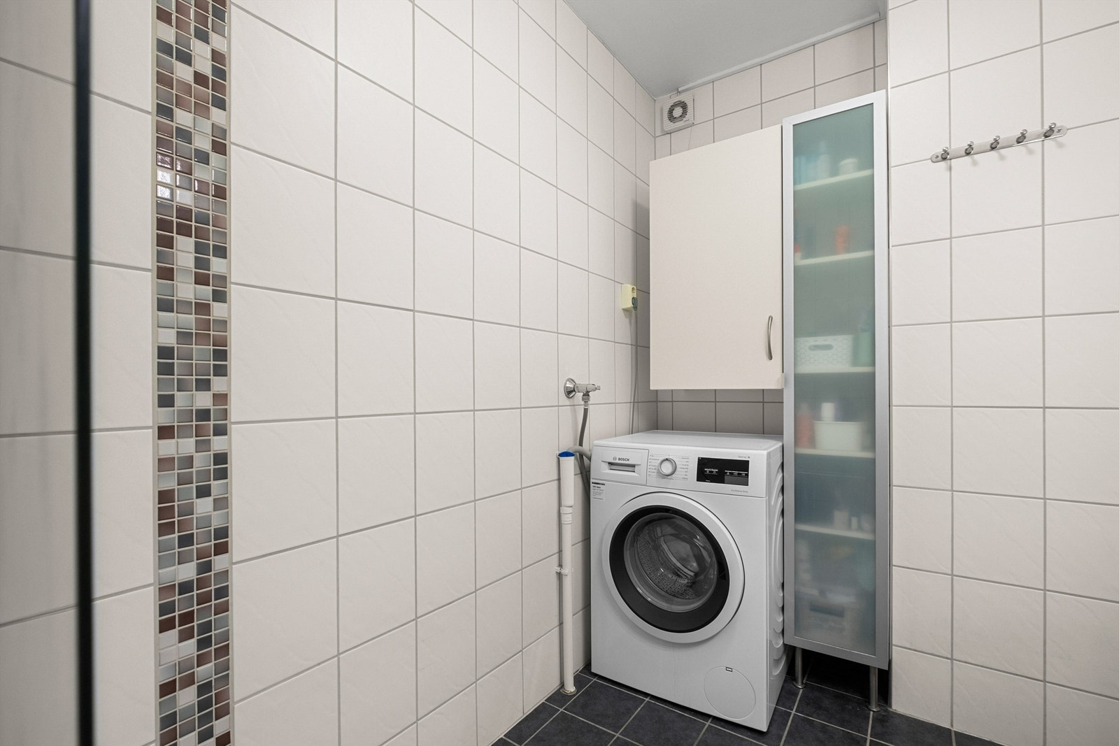 Videre er badet utstyrt med servantskap med speil og lys, badekar med vegghengt badekararmatur samt sideskap. Galleribilde