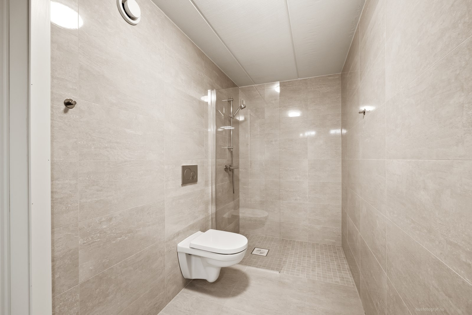 Badet er innredet med vegghengt toalett, dusjhjørne og har opplegg for vaskemaskin. Galleribilde