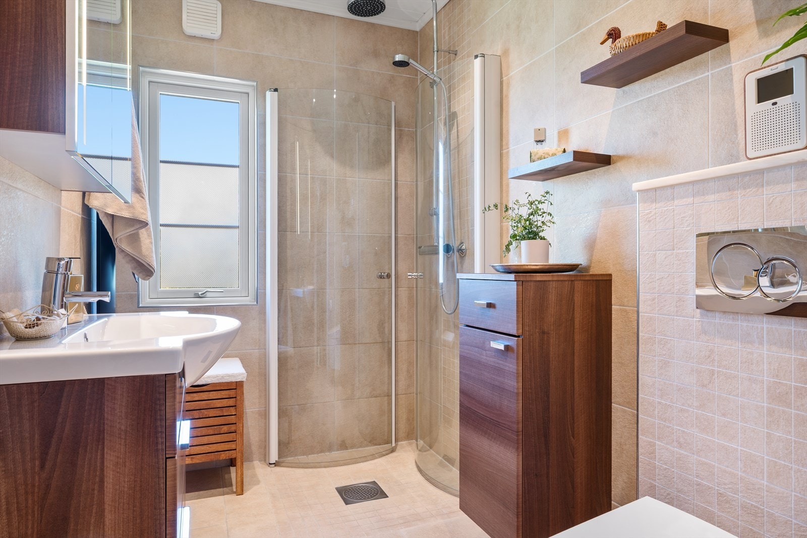 Badet i første etasje er helfliset og utstyrt med vegghengt toalett, dusjhjørne og moderne innredning. Galleribilde