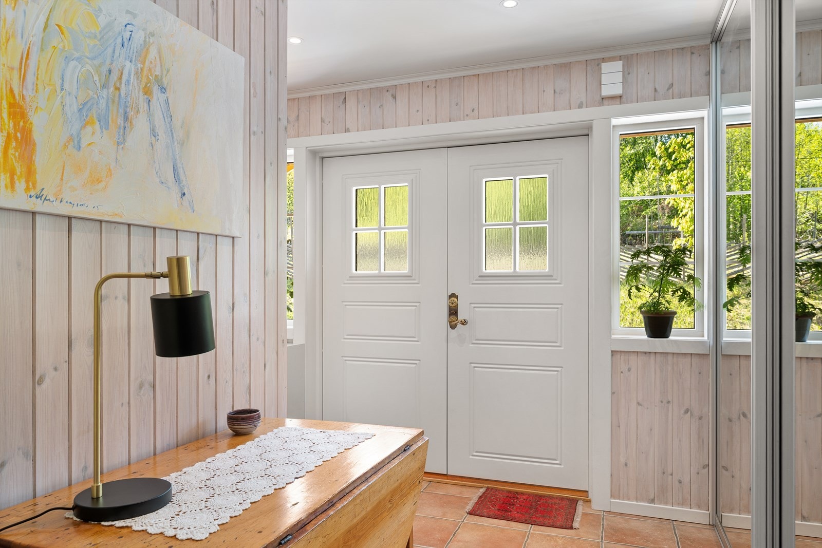 En lys og innbydende entré ønsker velkommen inn. Her er det god plass til oppbevaring i en stor skyvedørsgarderobe. Galleribilde