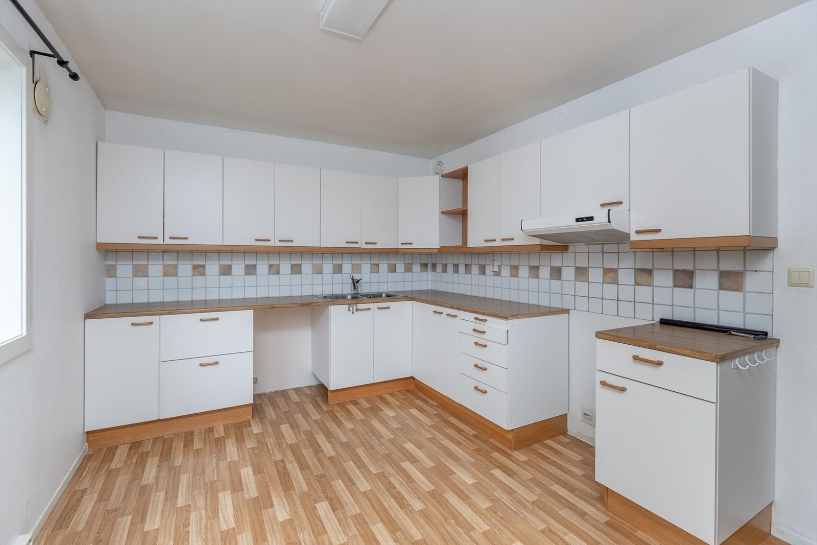 Det er en kjøkkenventilator med kullfilter samt avtrekk via sentralavtrekk i veggen. Galleribilde