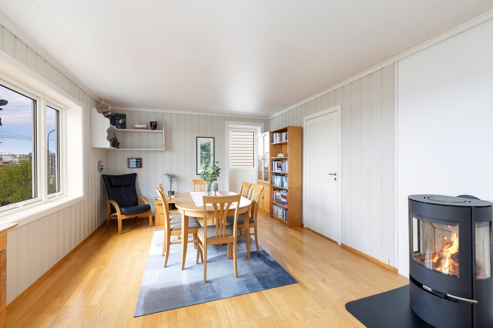 Spiseområdet er praktisk plassert med direkte tilgang til bokhyller og vedovn. Galleribilde