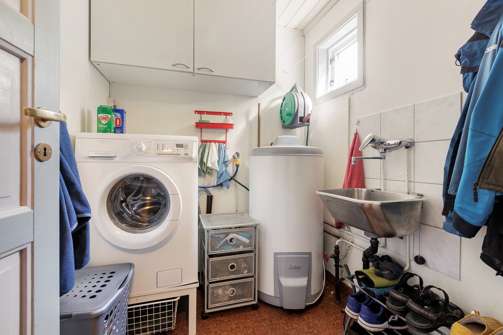 Praktisk vaskerom med plass til vaskemaskin, oppbevaring og arbeidsflate. Galleribilde