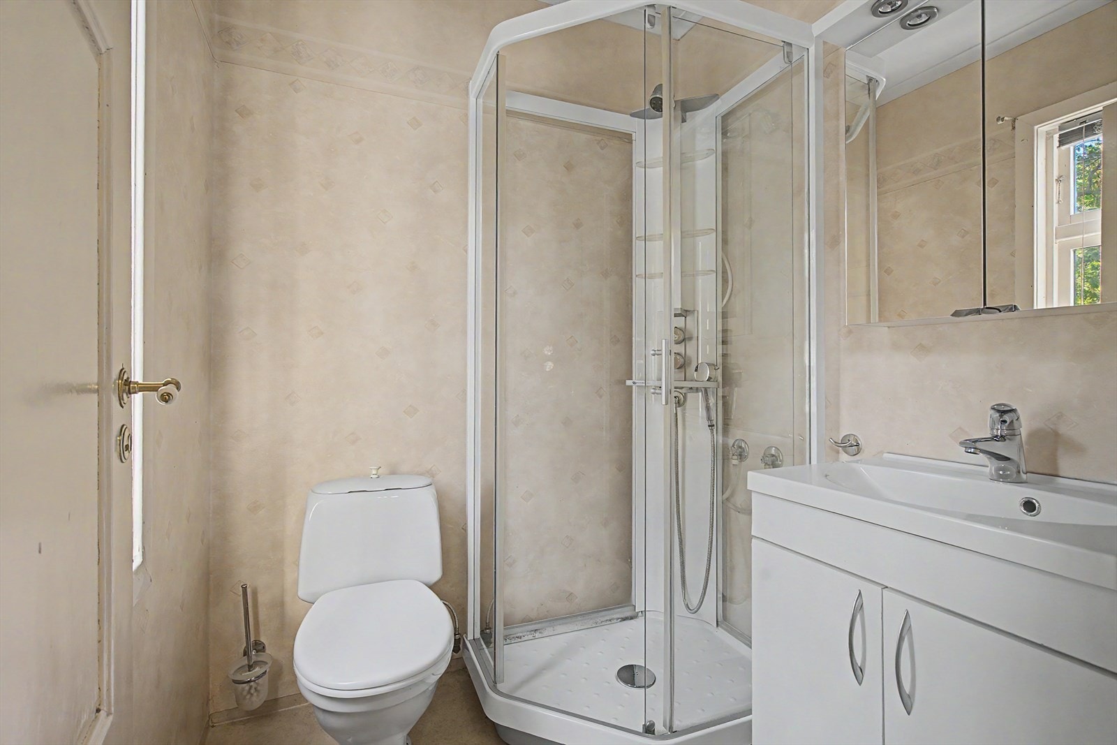 Badet i første etasje er utstyrt med dusjkabinett, toalett og servant med skap. Galleribilde