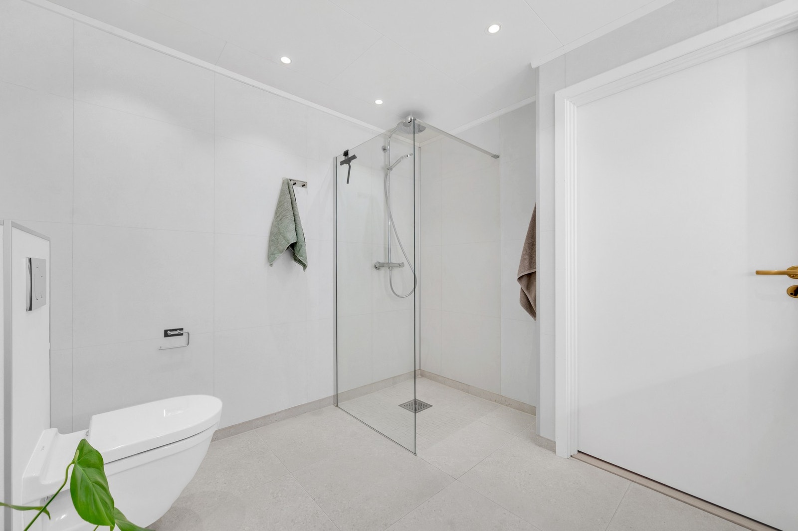 Lekre overflater med 60x60 fliser på gulv, plater på vegger, ny moderne innredning og en romslig dusjløsning. Foto: H5 Galleribilde