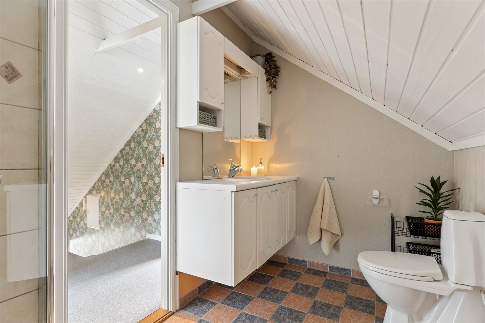 Pent bad på loftet med servant i seksjon, gulvstående toalett og dusjnisje. Galleribilde