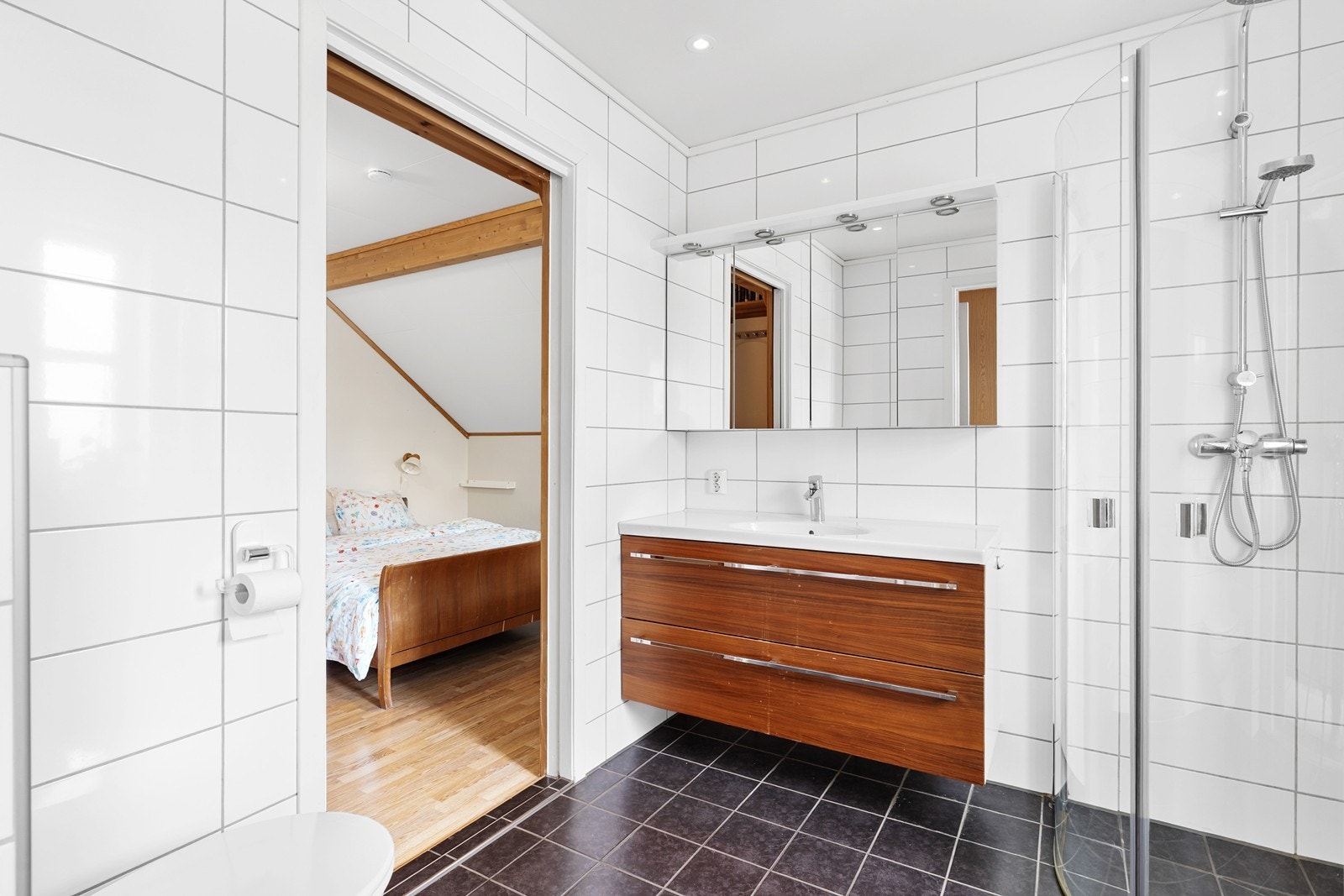 Badet i første etasje har flislagte vegger og gulv, samt vegghengt toalett og dusjløsning fra 2012. Galleribilde