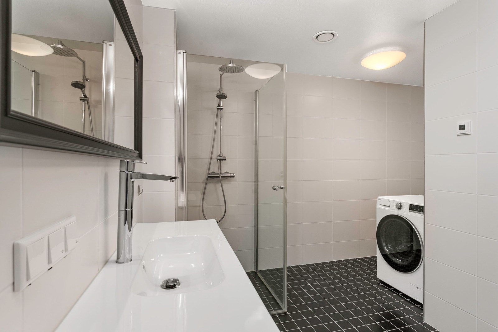 Badet har servantmøblement dusjsone, speil og vegghengt toalett. Opplegg for vaskemaskin. Galleribilde