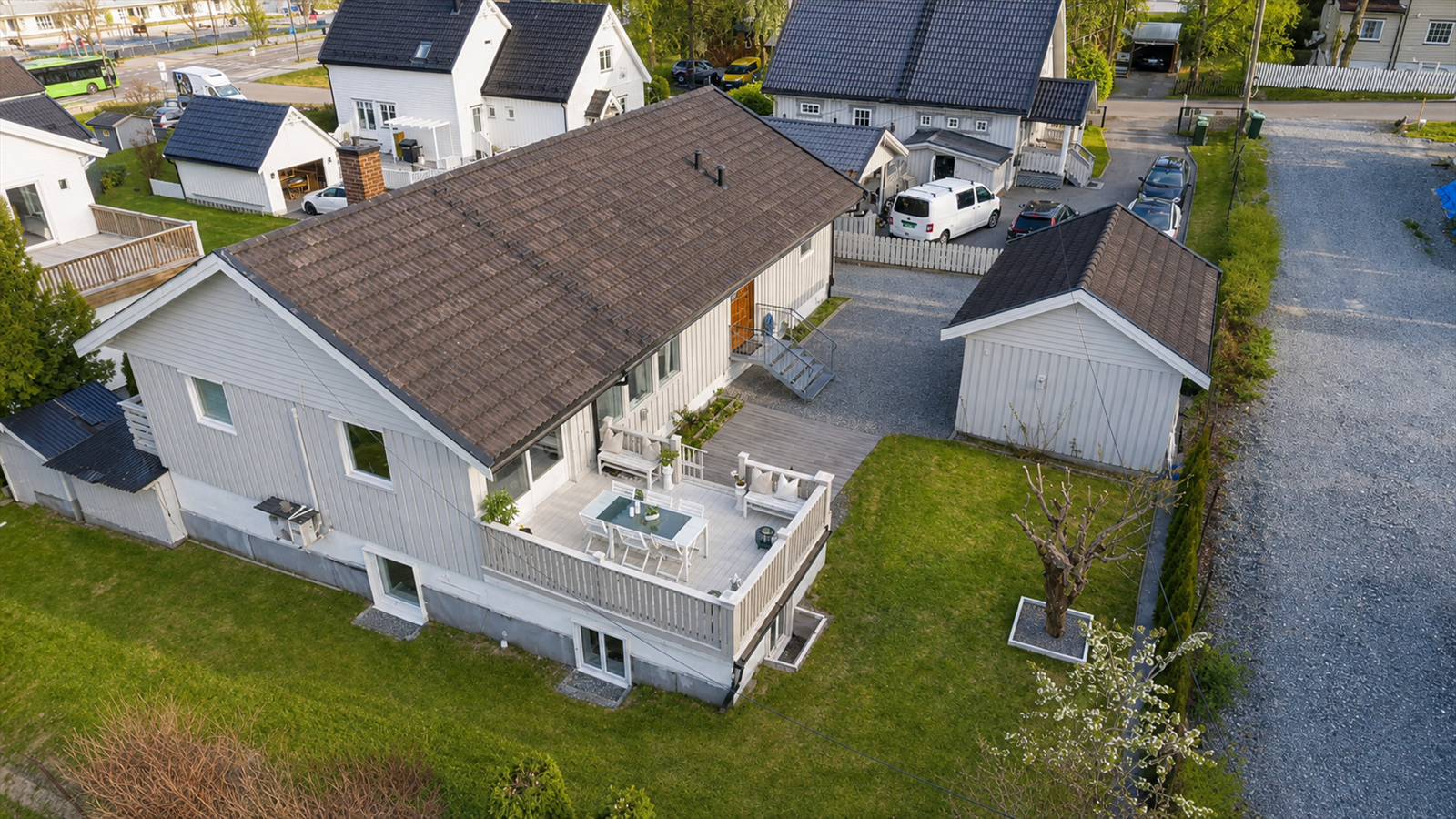 Dronebilde av en flott og frodig hage og bakdelen av huset. Galleribilde