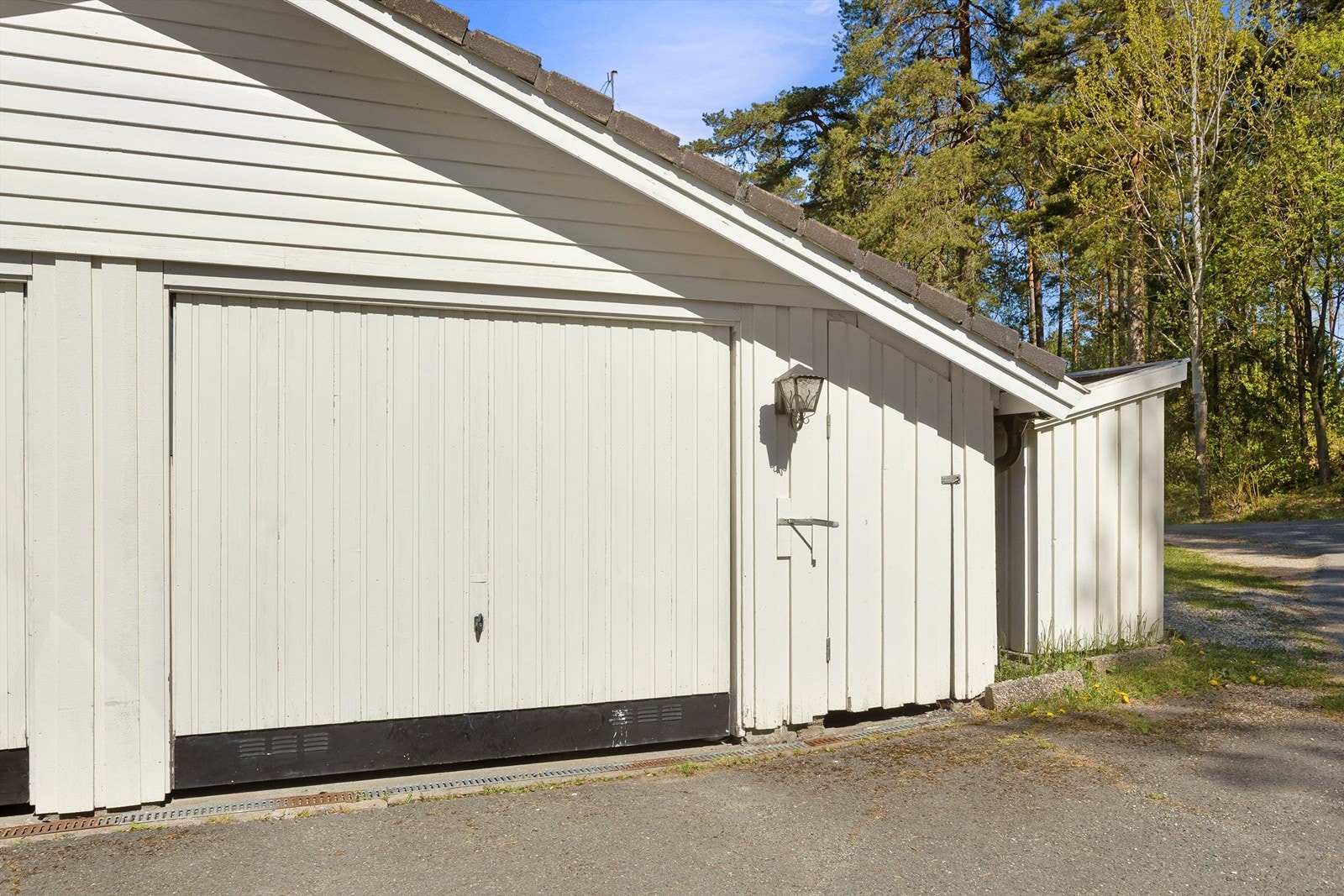 Parkering for en bil i halvpart av av dobbel garasje som eies sammen med nabo Galleribilde