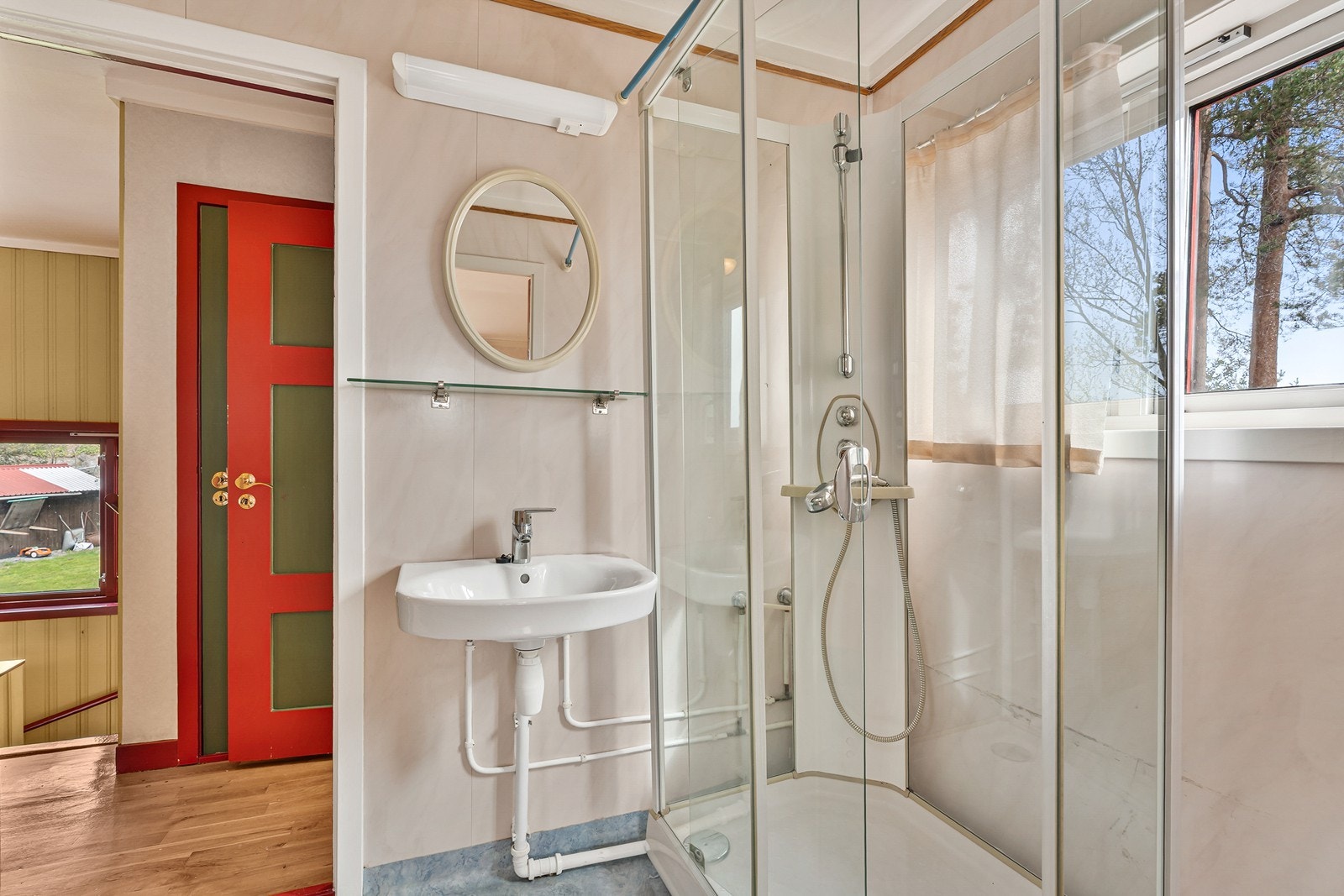 Badet har vinylbelegg på gulv og baderomsplater på vegger. Rommet er utstyrt med vask og dusjkabinett. Galleribilde