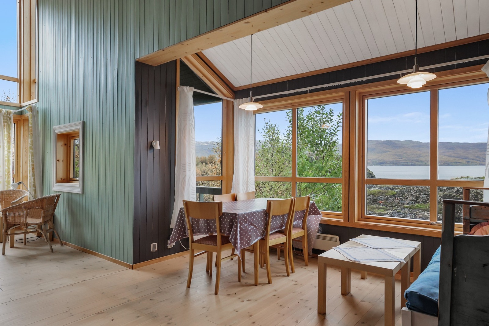 Dette er hyttas hjerte, et sosialt og åpent rom preget av en imponerende takhøyde med skråtak og synlige takbjelker, noe som skaper en fantastisk romfølelse. Galleribilde