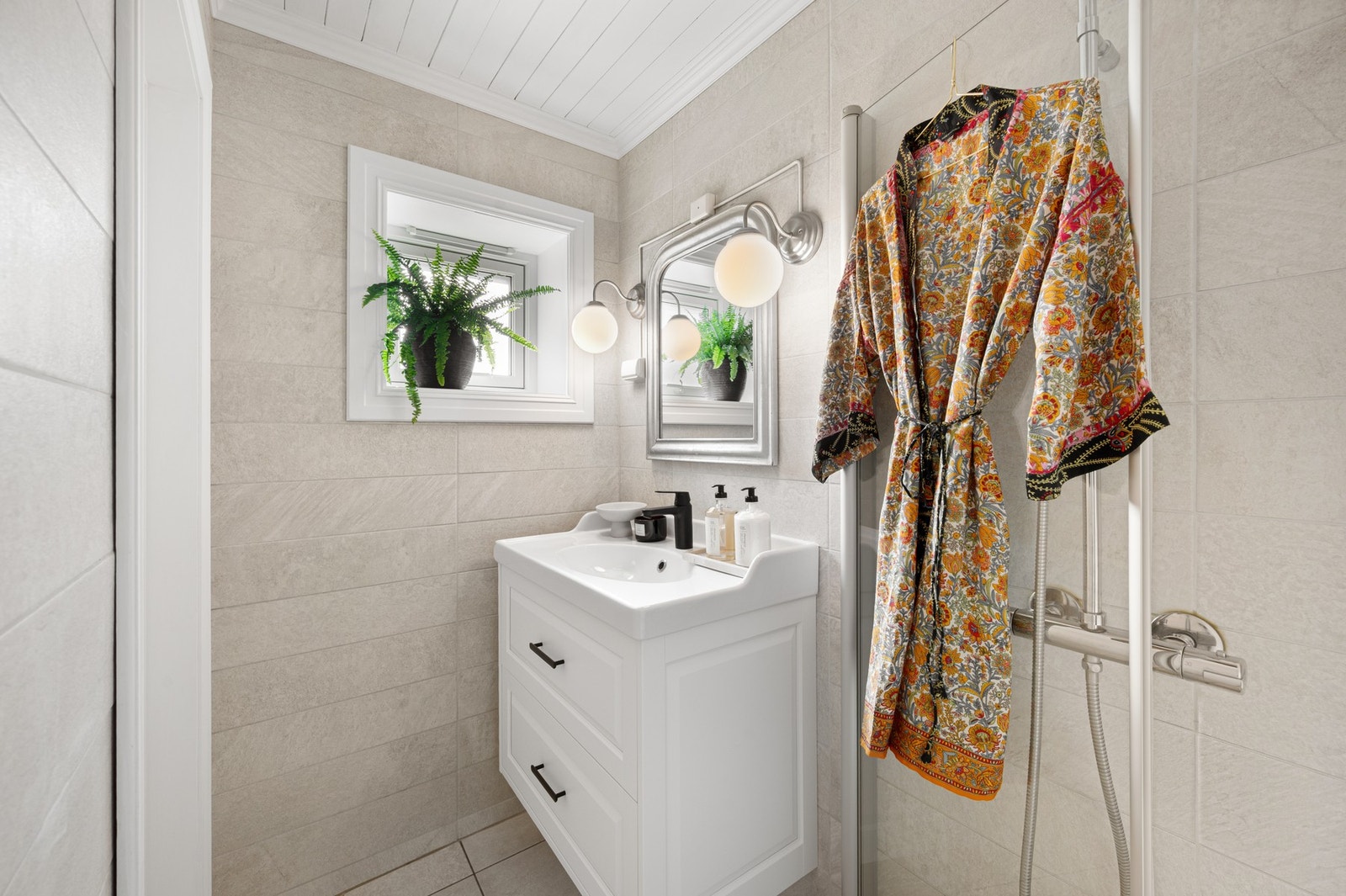 Badet er bl.a innredet med plassbesparende innfellbare dusjdører og baderomsinnredning med lagringsplass. Galleribilde