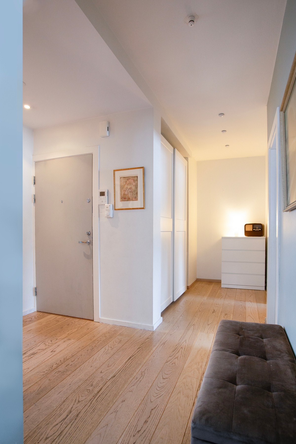 Du ønskes velkommen inn i en lys og innbydende entré med enstavs parkett på gulv med gulvvarme, glatte lysmalte overflater og downlights i himlingen. Galleribilde