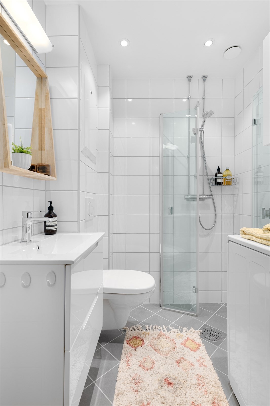 Badet er innredet med servant på servantskap, toalett, dusjhjørne og opplegg for vaskemaskin. Galleribilde