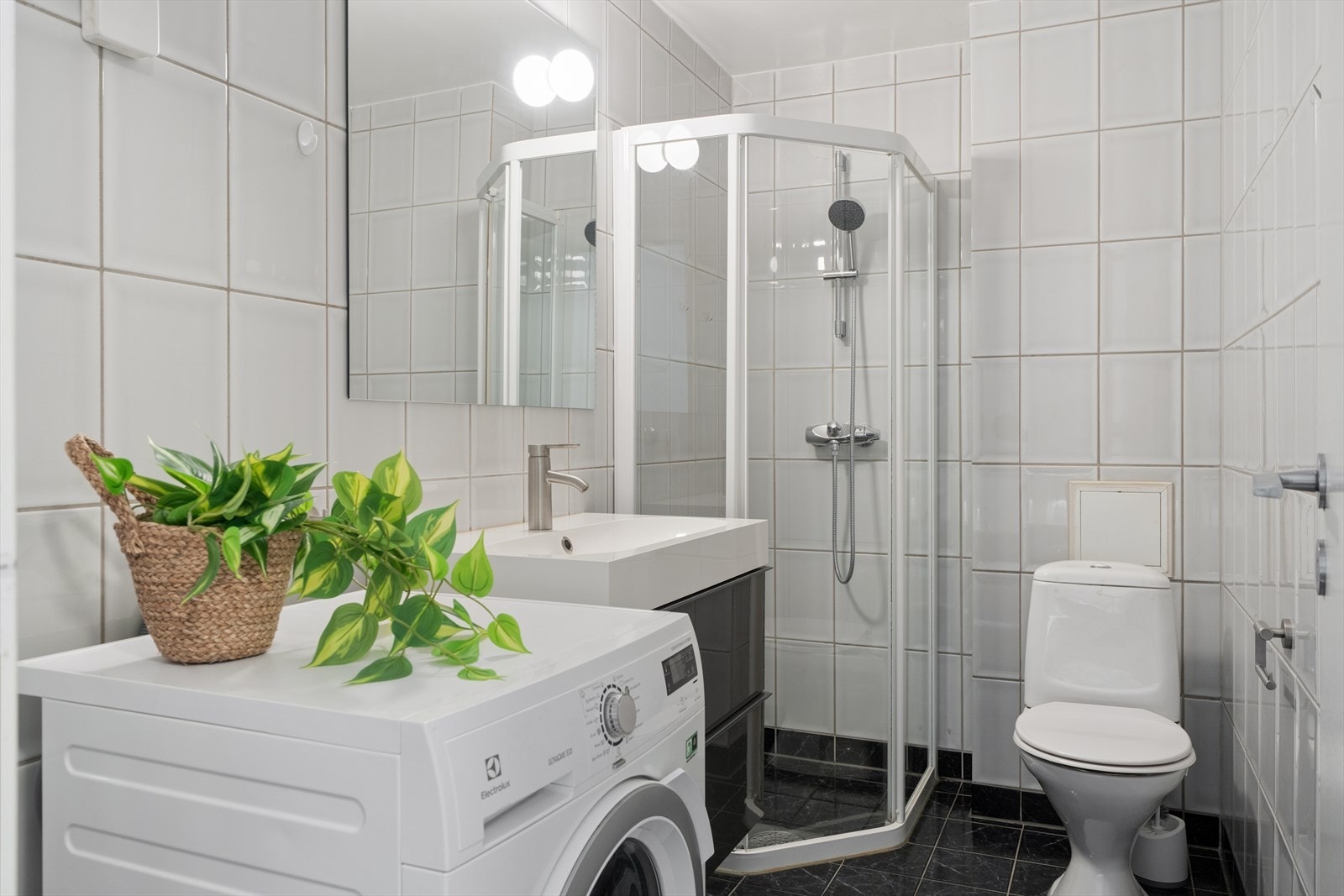 Badet er flislagt og utstyrt med dusjvegger. Opplegg for vaskermaskin Galleribilde