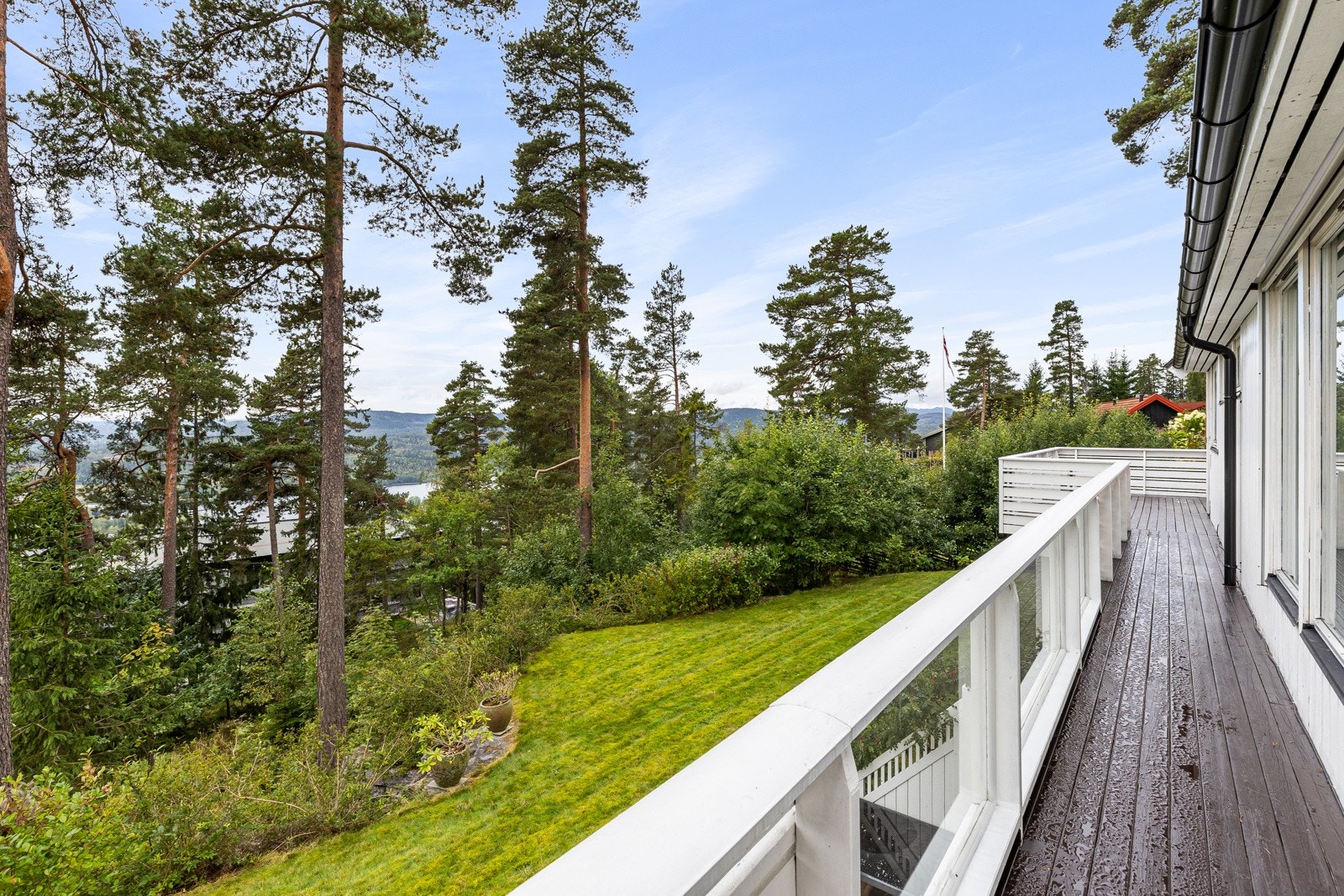 Verandaen har gode solforhold og flott utsikt utover eiendommens pent opparbeidet hage. Galleribilde