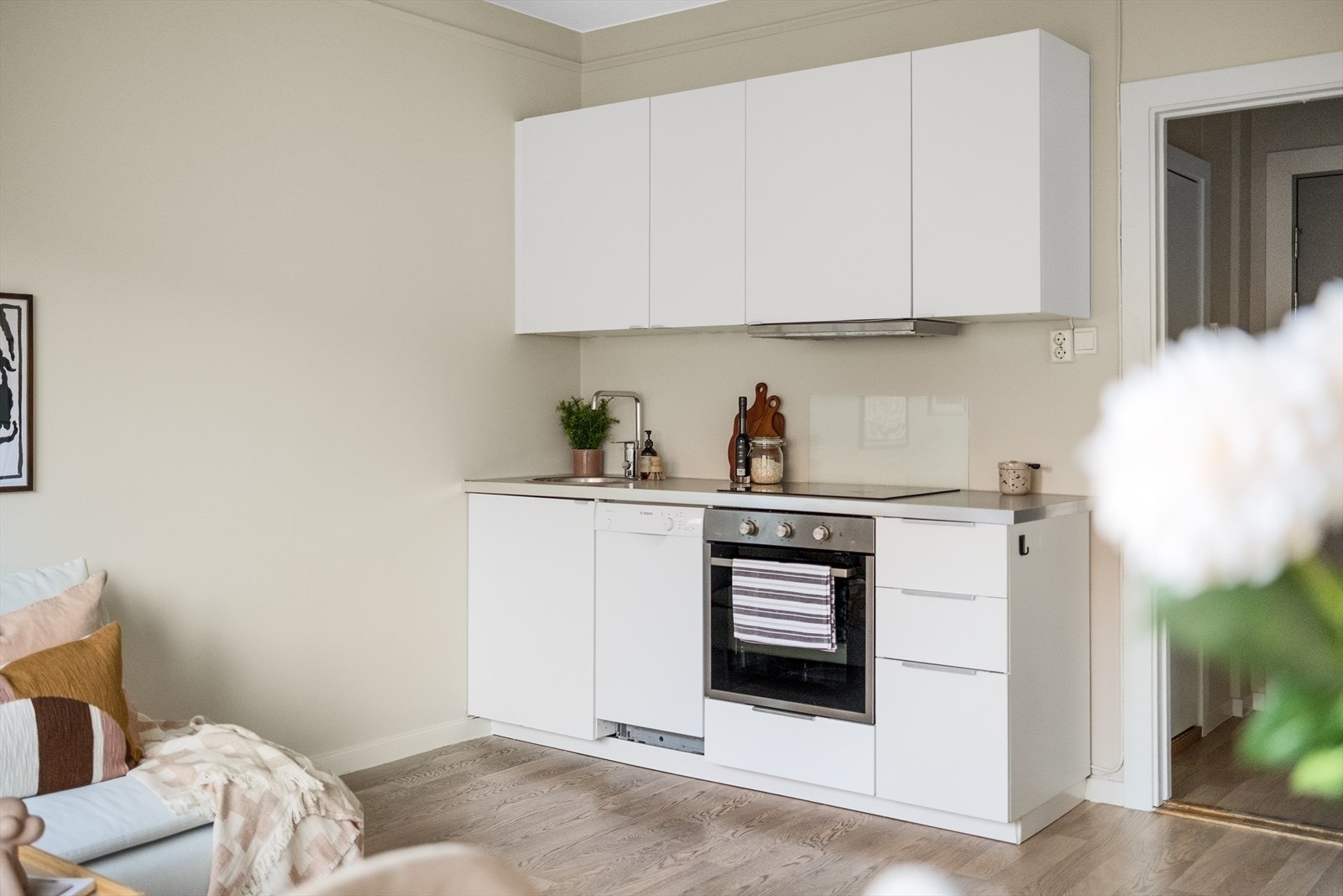 Moderne og pent kjøkken fra IKEA med soft close, laminat benkeplate med nedfelt stålkum og keramisk topp, integrert komfyr, oppvaskmaskin (smal type) og frittstående kjøl- og fryseskap. Galleribilde