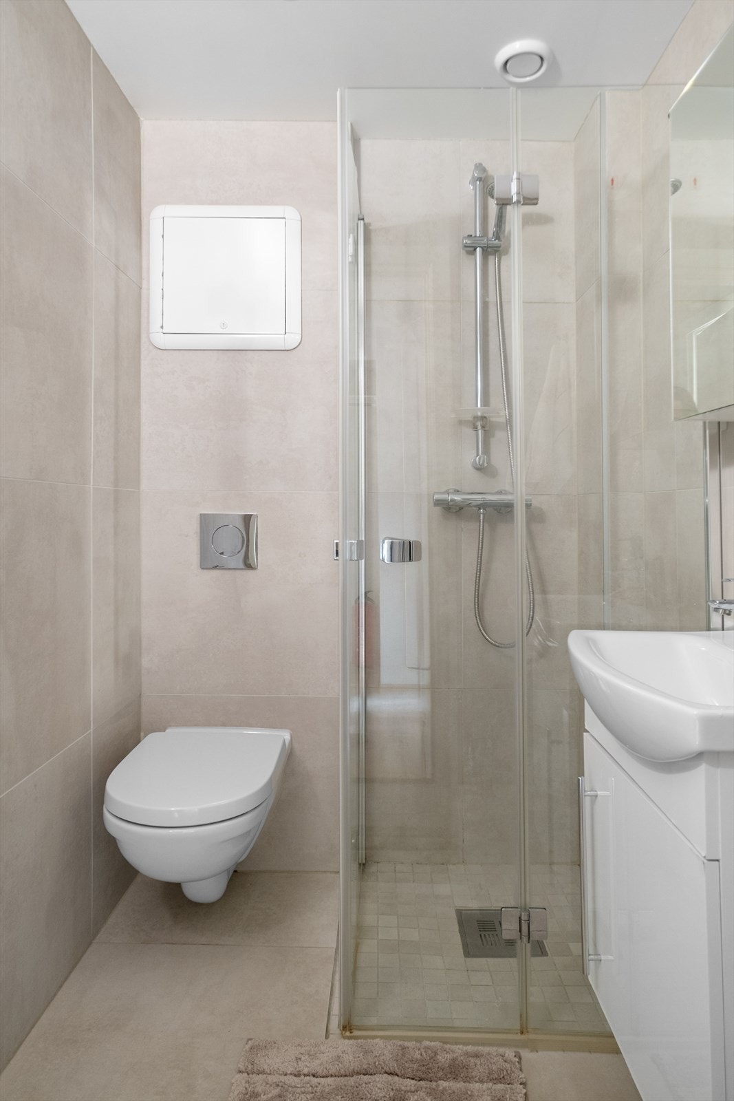 Videre inneholder badet dusjsone med innfellbare glassdører og opplegg for vaskemaskin. Galleribilde